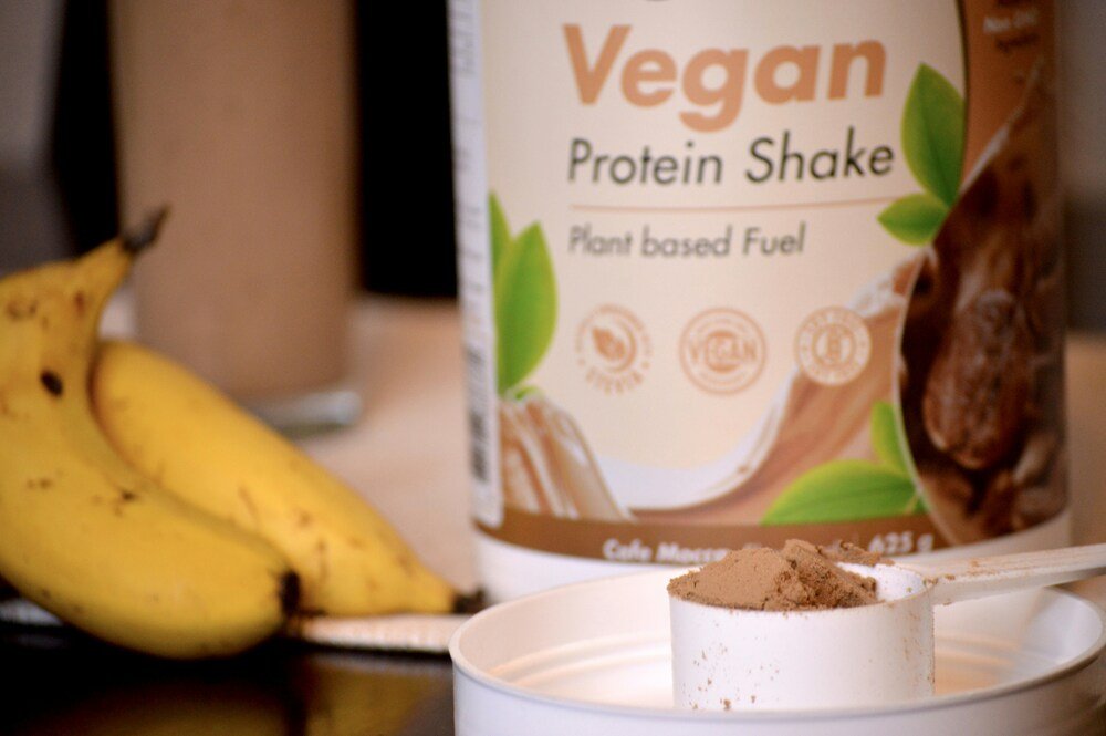 Pote branco com rótulo de proteína vegetal em pó para fazer shakes como exemplo de susbstituição do whey protein aos alérgicos e intolerantes à lactose